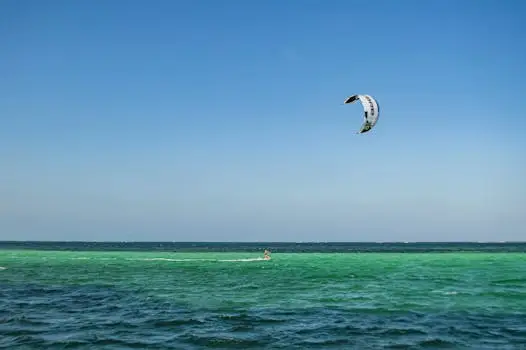 Exciting kitesurfing at scenic Diani Beach, Kenya, under a clear blue sky.